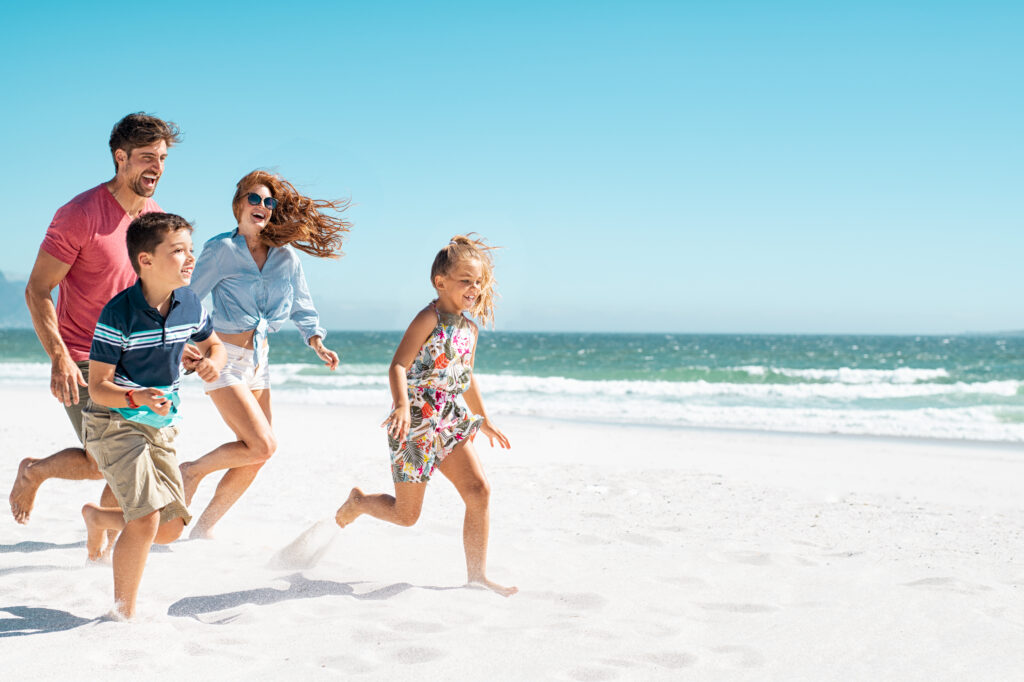 Example of a healthy dad running with family on the beach.